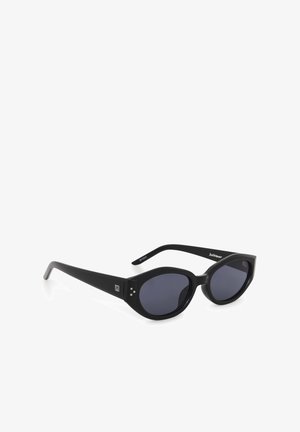 Schwarze ovale Sonnenbrille mit dicken Rahmen und dunklen Gläsern, mit einem kleinen weißen Logo am Bügel und drei silbernen Punkten in der Nähe der Scharniere.