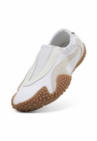 Λευκό παπούτσι slip-on με ανάγλυφες μπεζ σουέντ λεπτομέρειες και σόλα από καουτσούκ με ανυψωμένες λαστιχένιες κουκκίδες για καλύτερη πρόσφυση, σε κεκλιμένη γωνία.