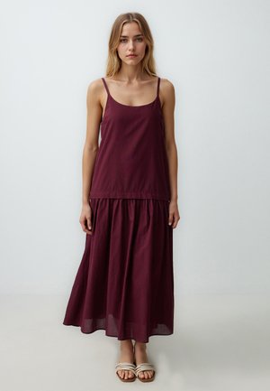 Bordeaux mouwloze maxi-jurk met een getailleerde bovenkant en een vloeiende, gelaagde rok, gemaakt van lichtgewicht stof. Eenvoudig ontwerp met verstelbare bandjes.