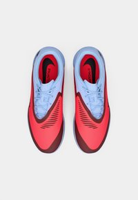 Red and blue athletic shoes with a textured upper, sleek design, and black accents. Features a lace-up closure and cushioned sole.