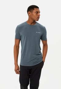 Heren T-shirt met korte mouwen in een donkere teal kleur, gemaakt van lichtgewicht stof met een ronde hals en een klein wit logo op de linkerborst.