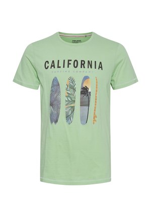 Világoszöld póló, amelyen a "CALIFORNIA SURFING COMPANY" felirat található, valamint négy, különböző mintázatú és színű, függőlegesen elhelyezett szörfdeszka.