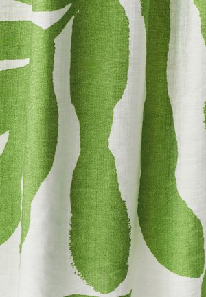 Tissu vert et blanc à motifs avec de grandes formes en feuille dans un tissage texturé, affichant des motifs audacieux de style coup de pinceau.