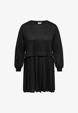 Črna obleka z oblikovanim korzetom, dolgimi napihnjenimi rokavi in tekočo krilno dolžino do sredine tele. Narejena iz mehke, lahkotne tkanine.