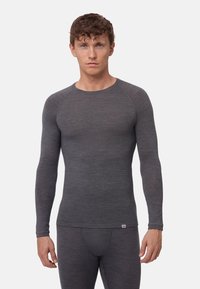 Grå langærmet termisk top lavet af et tekstureret, let materiale med rund hals og tætsiddende design, parret med matchende underdele.