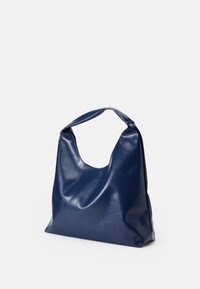 Granatowa skórzana torba hobo o gładkiej fakturze, miękkich krzywiznach i otwartym uchwycie dla łatwego noszenia. Prosty i nowoczesny design.