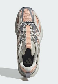 Grå och rosa sportskor med nätpaneler, vadderad krage och texturerad sula. Har reflekterande accenter och snörningsdesign.