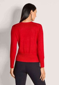 Roter gestrickter Pullover, eng anliegendes Design, lange Ärmel, gerippter Saum und Bündchen, weiche Textur, mit einer geraden Rückenansicht, die nahtlose Schultern zeigt.