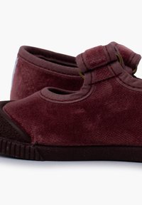 Scarpe in tessuto bordeaux con una morbida consistenza vellutata, dotate di una fascia e di hardware ad anello, punta tondeggiante e una suola in gomma scura a contrasto.