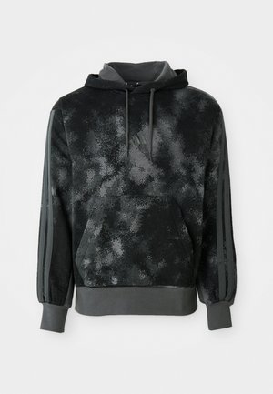 Sort hættebluse med et spættet mønster, kængurulomme og grå detaljer på ærmerne. Lavet af blødt, tekstureret stof med en rummelig hætte.