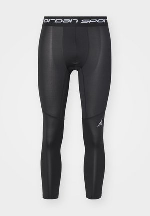 Sorte atletiske leggings lavet af et glat, strækkeligt materiale. Har et bredt taljebånd med "Jordan Sport"-tekst og et lille Jordan-logo nær anklen.