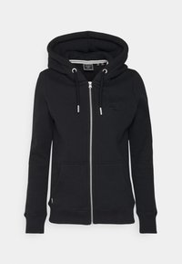 Sudadera con cremallera negra hecha de un tejido suave. Presenta una gran capucha, bolsillos delanteros y un logo texturizado en el pecho con cremallera plateada y cordones.