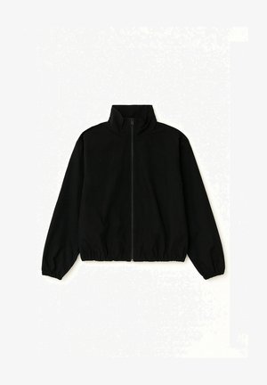 Czarna kurtka na zamek z wysokim kołnierzem, elastycznymi mankietami i elastycznym pasem, rozłożona na białym tle.