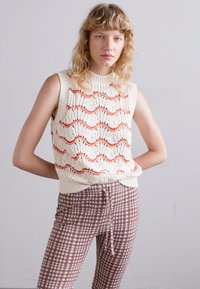 Desigual en crème sans manches, orné de motifs en vagues rouges, associé à un pantalon à carreaux marron avec une taille à cordon et une coupe slim.