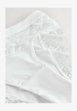 Balti apatiniai, pasižymintys lygiu audiniu su nėrinių apdaila kraštuose, rodančiais sudėtingus gėlių raštus ir švelnią tekstūrą.