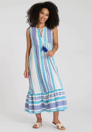 Robe maxi blanche avec des motifs bleus. Elle présente un décolleté avec nœud et un ourlet évasé. Fabriquée en tissu léger, idéale pour le temps chaud.