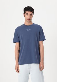 Navy blue short-sleeve t-shirt made of cotton. Features a crew neck and a small white logo print on the chest. Smooth texture, relaxed fit.