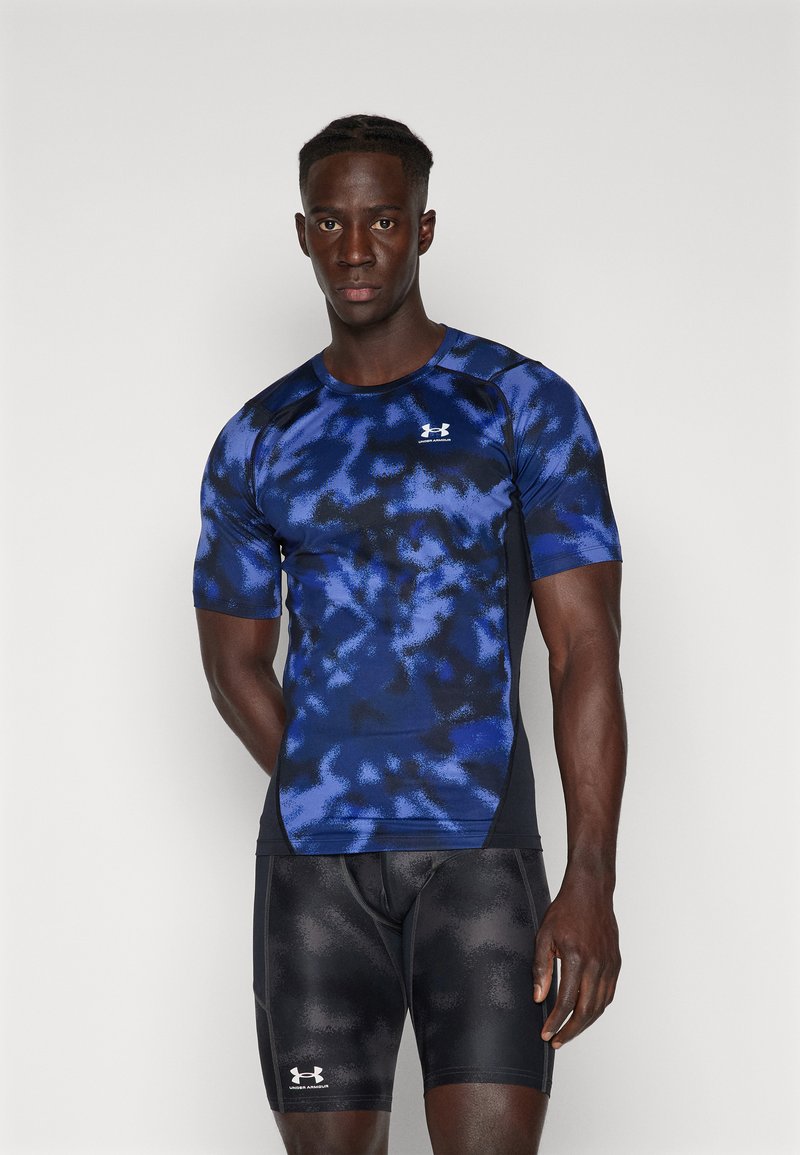 Marineblauw sportshirt met een gestructureerd, abstract patroon, korte mouwen en een ronde halslijn, gecombineerd met zwarte aansluitende shorts.
