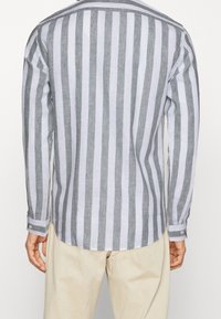 Gestreiftes langärmliges Hemd in Grau und Weiß aus Leinen, mit abgerundetem Saum, knöpfbaren Manschetten und klassischem Kragen.