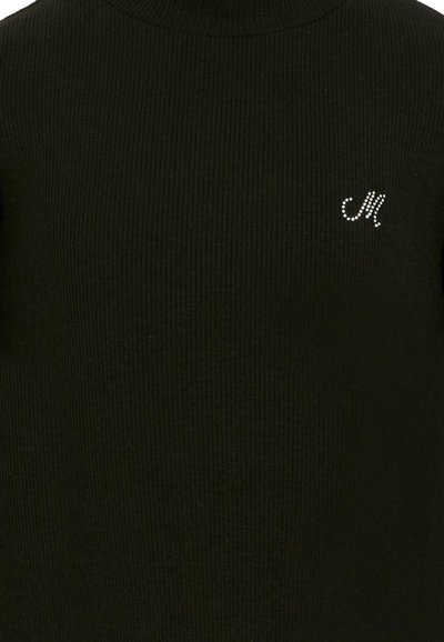 Primo piano di un tessuto nero a coste con un piccolo dettaglio in strass a forma di "M" sul lato superiore destro.