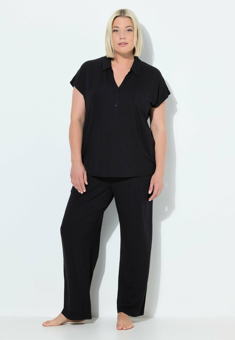Zwart twee-delig loungewear set bestaande uit een kortärmige overhemden met knopen en een zak, gecombineerd met loszittende broek, gemaakt van zachte stof.