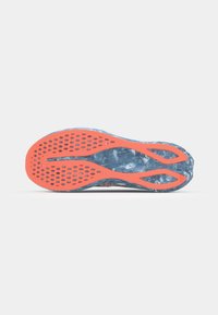 Semelle de chaussure avec un motif texturé bleu et des accents orange. Comprend des trous de ventilation et un design épuré pour une meilleure adhérence.