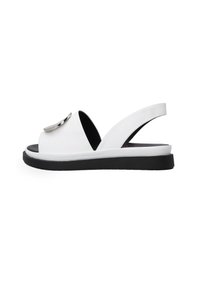 Weiße Leder-Slingback-Sandale mit großem metallischem Akzent, offener Zehenpartie und schwarzer Sohle. Minimalistisches Design mit glatter Textur und eleganter Form.