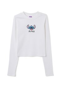 Weißes langärmeliges Crop-Top aus geripptem Stoff, das eine bestickte blaue Figur und den Schriftzug "ALOHA" darunter zeigt.