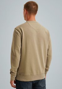 Beige mikina s dlhými rukávmi a okrúhlym výstrihom. Mäkká, textúrovaná tkanina s voľným strihom. Hladké manžety a lem.