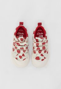 Weiße Leinenschuhe mit einem roten Erdbeerprint, elastischen Riemen und rotem Innenfutter. Gummisohle mit erhabener Struktur für besseren Grip.
