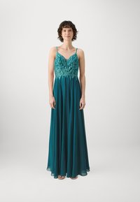 Teal večerna obleka z tankimi naramnicami, okrašena bodice s zapletenim delom iz perlic, tekoča krila in gladka, lahka tekstura.
