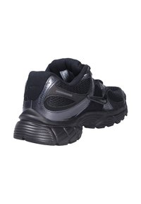 Chaussure de sport noire avec tige en mesh, superpositions en plastique, col rembourré et semelle extérieure en caoutchouc texturé. Dotée d'accents réfléchissants et d'une sangle ajustable.