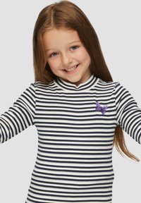 Gestreepte lange mouwen shirt met marineblauwe en witte patronen, met een paarse vlinderpatch op de linkerborst en een hoge hals.