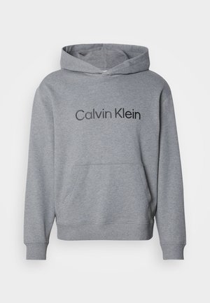 Grijze hoodie met een voorzak en het "Calvin Klein" logo in zwarte tekst over de borst gedrukt.