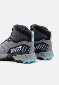 Graue Wanderschuhe mit schwarzen und blauen Akzenten. Sie verfügen über ein strukturiertes Material, hohen Knöchelhalt und eine robuste Sohle für besseren Halt. SCARPA-Logo sichtbar.