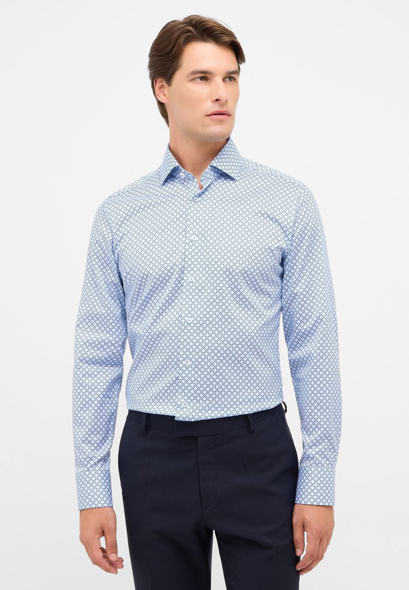 Camicia a maniche lunghe blu chiaro con un motivo geometrico in blu scuro. Collo classico, chiusura con bottoni davanti e design aderente.