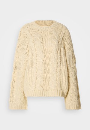 Kremfarget kabelstrikket genser med rund hals og lange, vide ermer. Har teksturerte mønstre og ribbede mansjetter og hem.