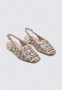 Zapatos slingback trenzados con punta cuadrada, que presentan una mezcla de tonos beige y acentos metálicos, con tacón bajo y diseño de parte posterior abierta.
