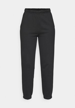 Black tapered sweatpants with elastic waistband and cuffs, front pockets, made of soft fabric.