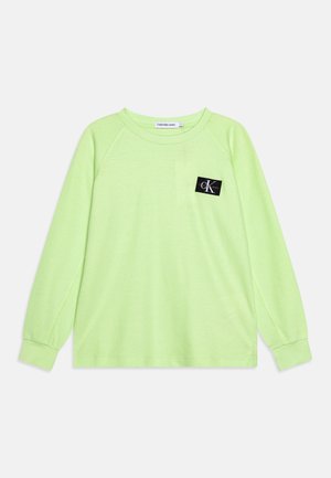 Lysegrøn langærmet T-shirt med rund hals og Calvin Klein Jeans logo patch på venstre bryst.