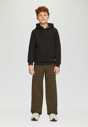 Zwarte hoodie met een kangoeroezak, gecombineerd met olijfgroene wijde broek en lichtgekleurde sneakers. Gladde stoffen textuur.