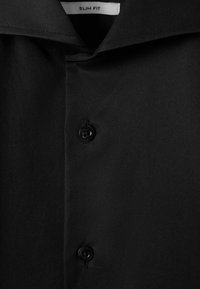 Cămașă neagră slim-fit cu un guler clasic, placket frontal cu două butoane negre și un material neted, texturat.