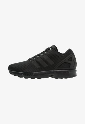 Sneaker sportiva nera con tomaia in mesh, tre strisce laterali, chiusura con lacci e suola ammortizzata, vista dal lato esterno.