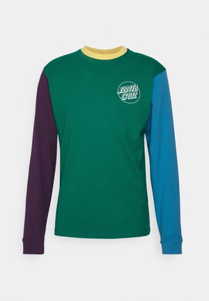 Langærmet rundhalset trøje med grøn krop, lilla venstre ærme, blåt højre ærme, gul krave og hvidt "Santa Cruz" logo på brystet.