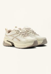 Leichte Sneakers aus cremefarbenem und beigem Netzmaterial mit strukturierten Einsätzen, gepolsterter Zunge und kontrastierender gummierter Sohle. Mit Schnürdesign.