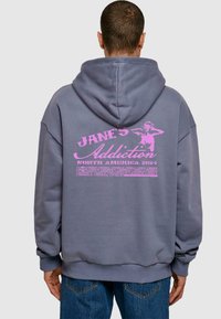 Felpa oversized grigia con stampa grafica rosa che presenta testo e illustrazione sul retro. Cappuccio spazioso e polsini a costine.
