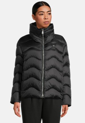 Zwarte pufferjack met een hoge kraag, zigzag quiltpatroon, glanzend materiaal en een centrale rits. Heeft een logo op de borst.