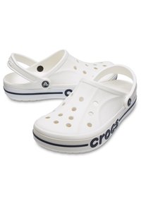 Białe klapki z pianki z otworami wentylacyjnymi, paskiem na tyle i granatowym akcentem po boku z nazwą marki "crocs".