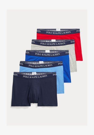 Cinq paires de boxers Polo Ralph Lauren en rouge, gris, bleu foncé, bleu clair et marine, empilées avec les ceintures élastiques de marque visibles.