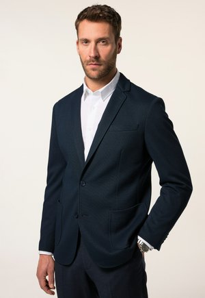 Dunkelblaues Blazer aus strukturiertem Stoff, mit Ein-Knopf-Verschluss, schmalen Revers und Fronttaschen, kombiniert mit einem weißen Hemd.